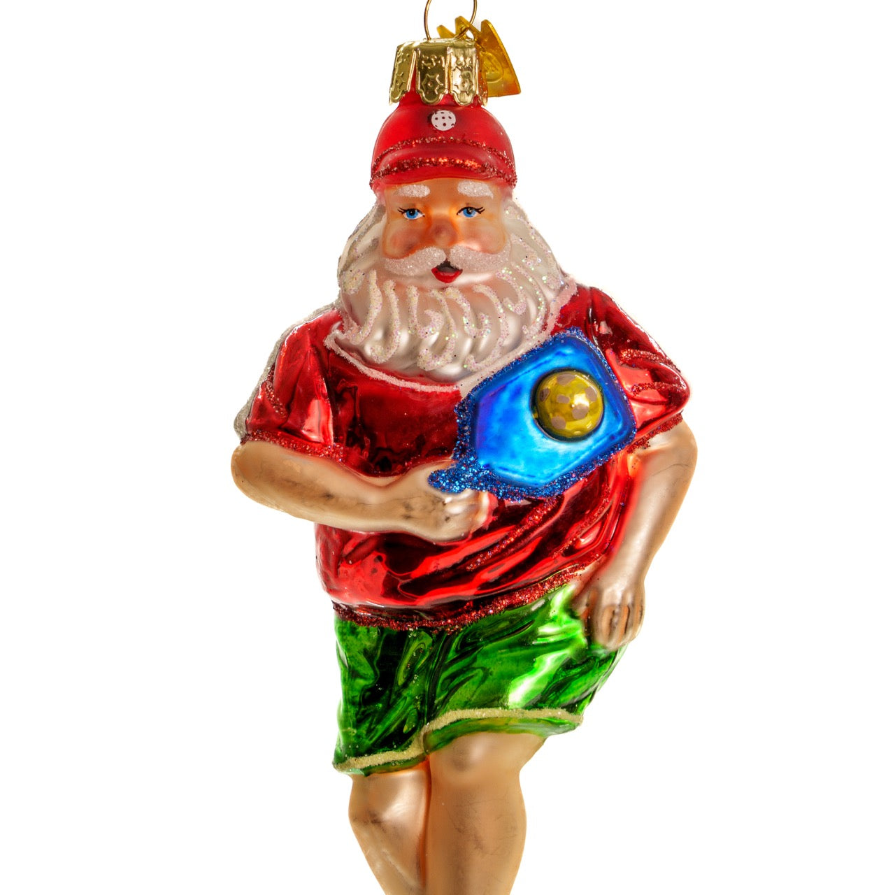 Close up of an elegant handmade glass Christmas ornament of Santa playing pickleball hanging in front of a white studio backdrop