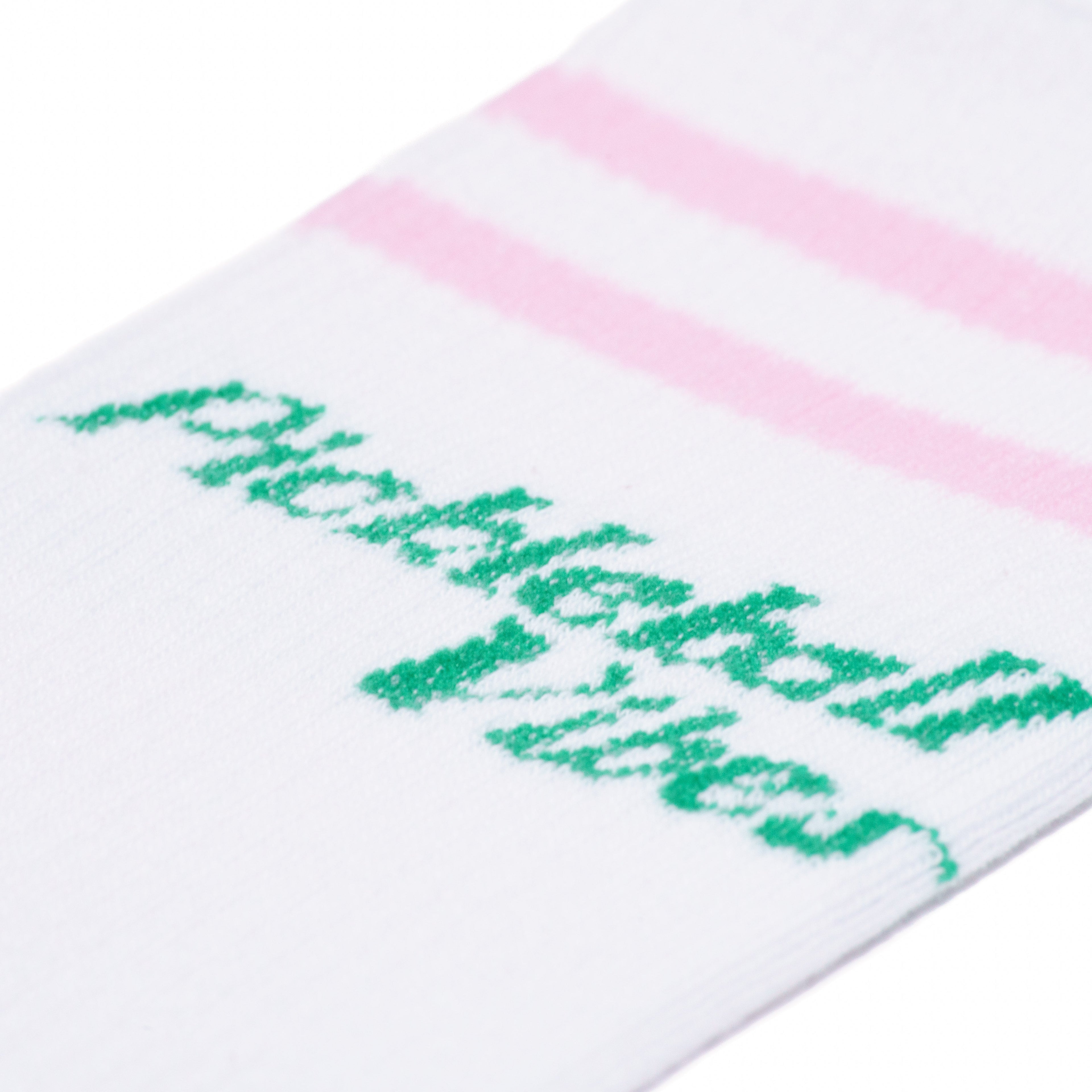 Detailed view of white mid calf socks with pink stripes and green text that says "Pickleball Vibes"