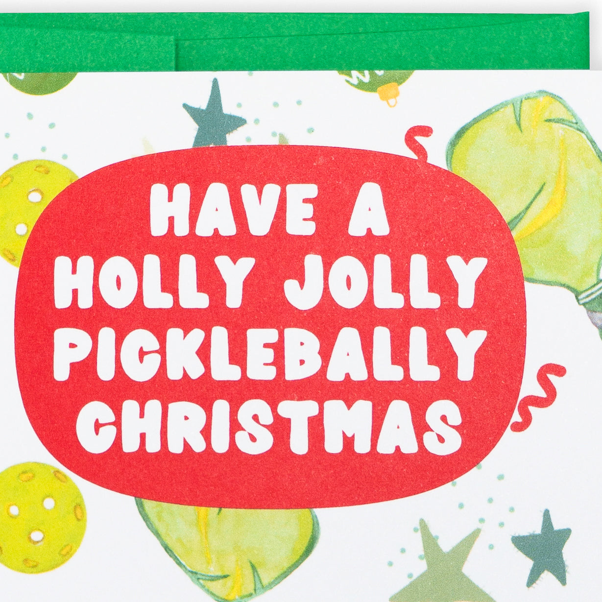 Close up of a festive pickleball Christmas card that says Have A Holly Jolly Picklebally Christmas
