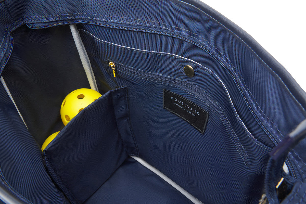 Built in ball pocket in inside of white and navy pickleball tote bag