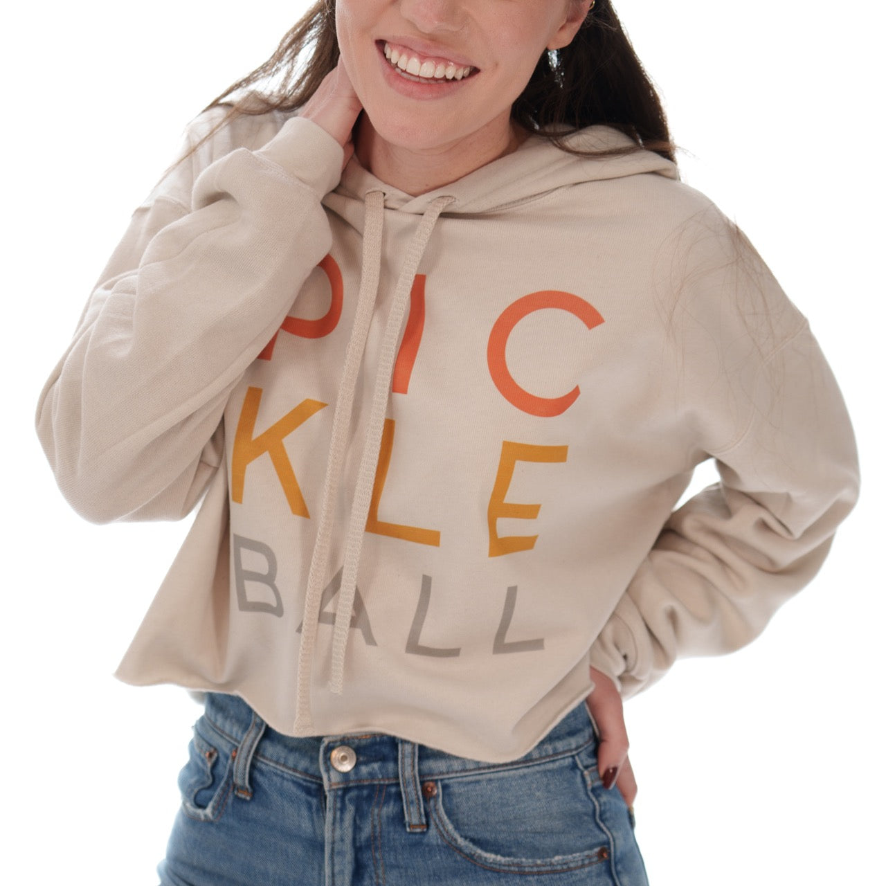 Woman wearing a cropped hoodie sweatshirt that says "PICKLEBALL" on it
