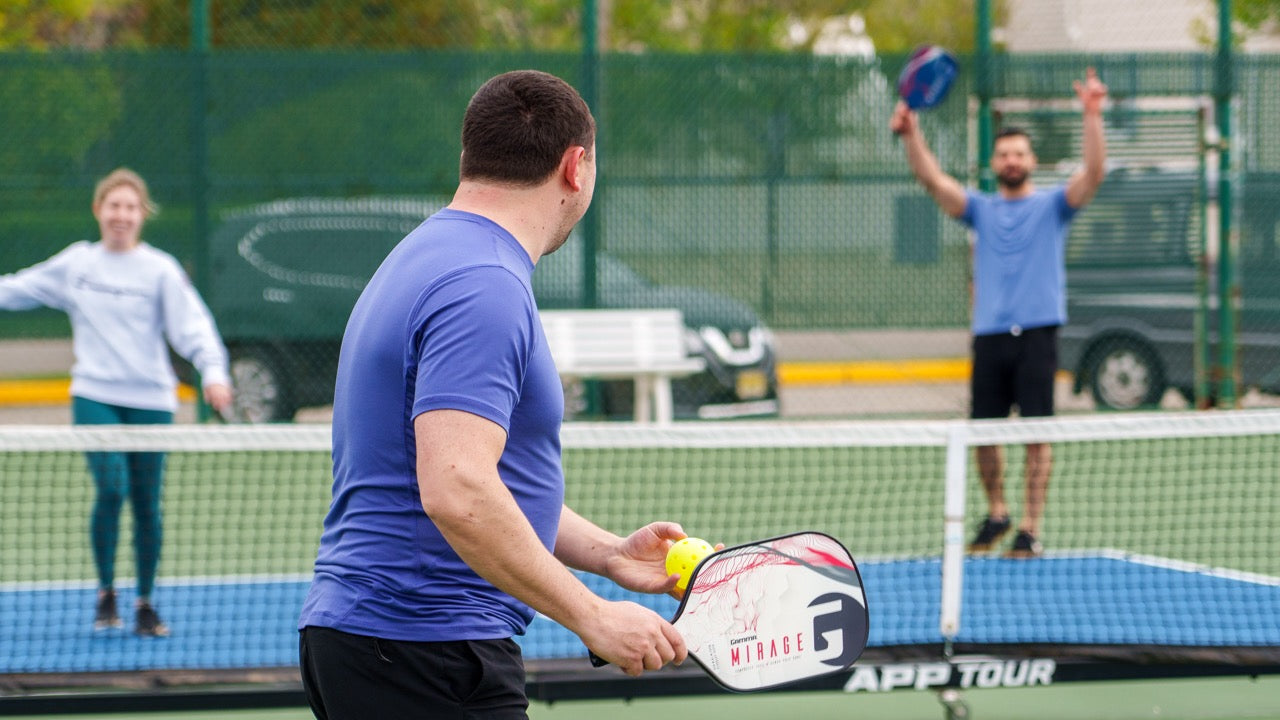 Three players on a pickleball court having a good time