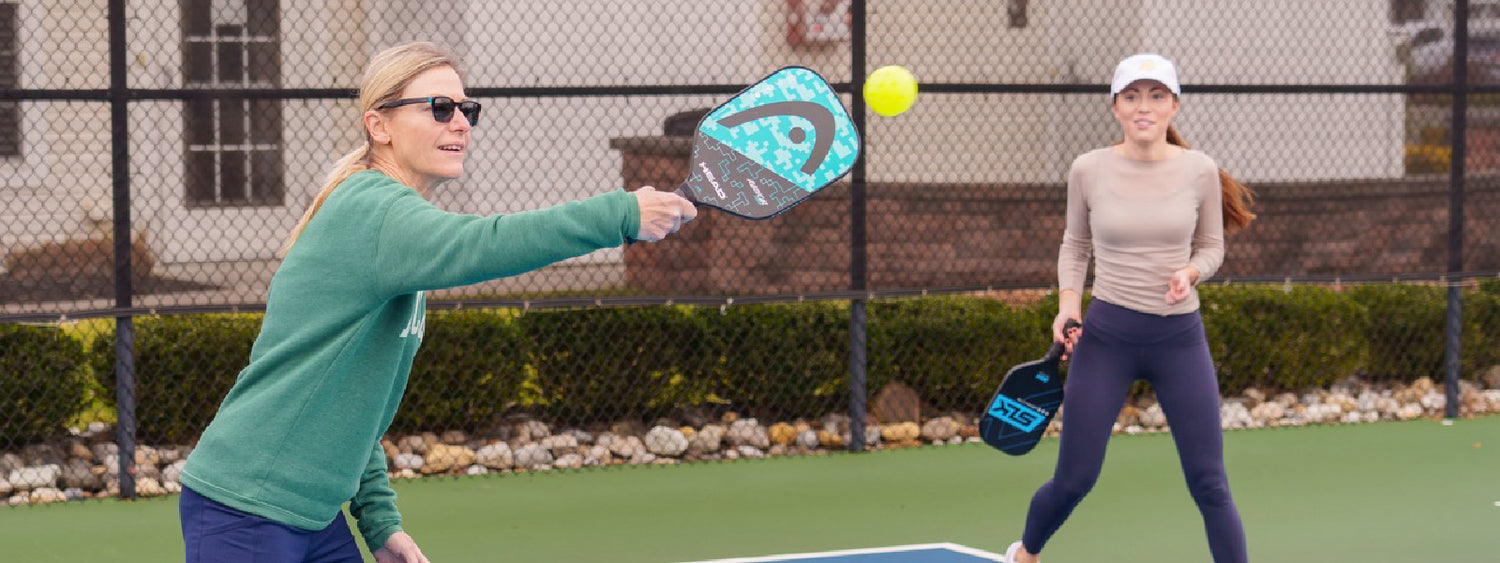 Mother and daughter laughing after a game of pickleball.