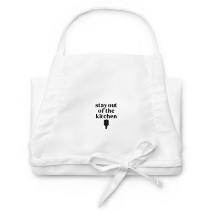 Folded embroidered white apron that says &quot;stay out of the kitchen&quot; and has a pickleball paddle on it