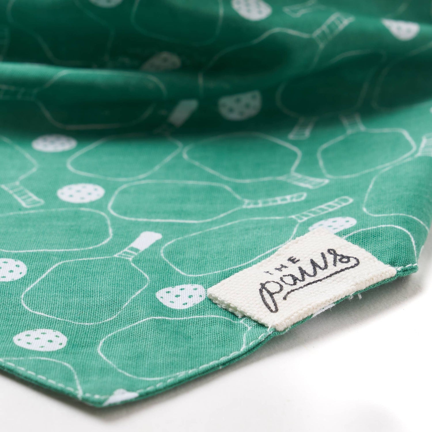 Detailed view of tag on green pickleball-themed dog bandana
