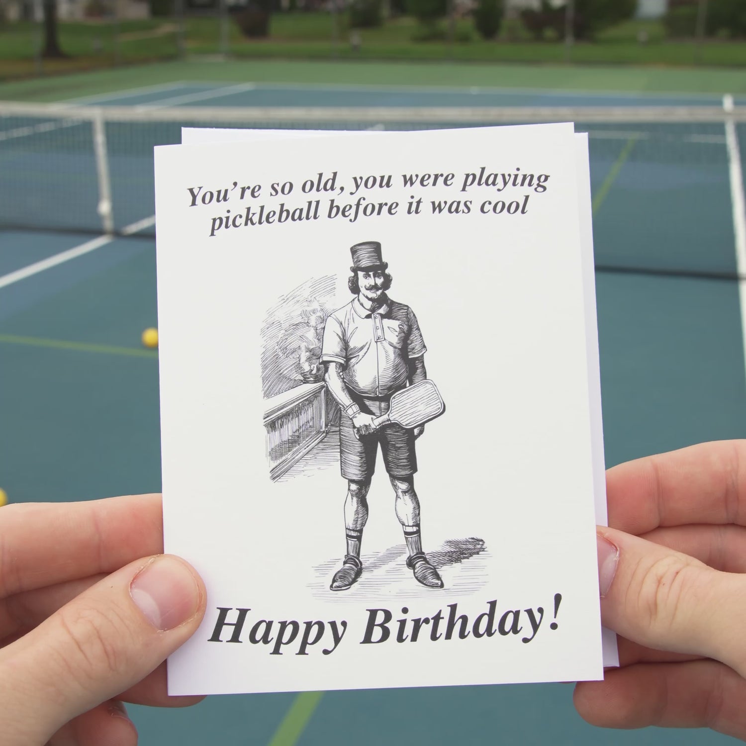 Video of a funny pickleball themed birthday card featuring a victorian era man holding an old wooden pickleball paddle.