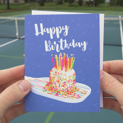 Video of a pickleball birthday card featuring a pickleball paddle and a birthday cake on top of it
