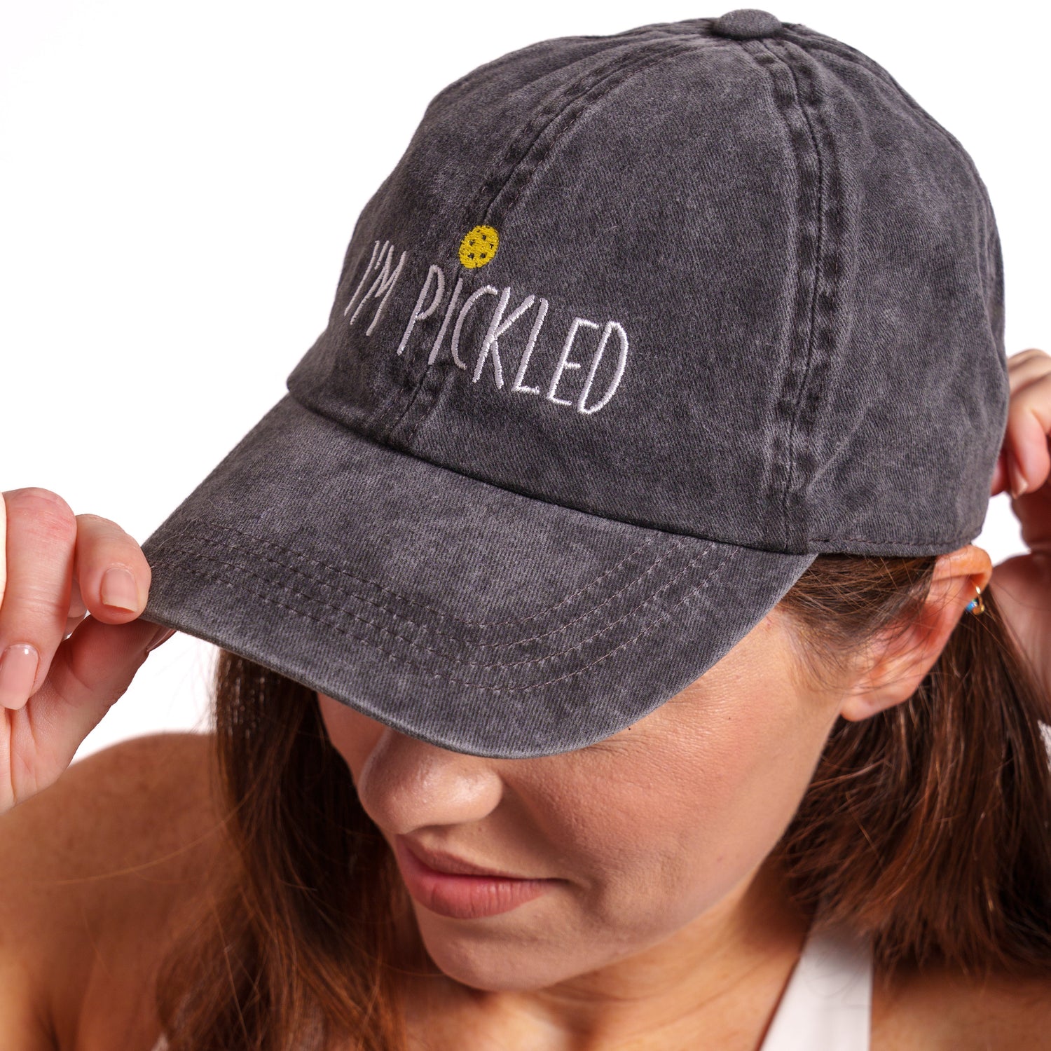 Side view of woman wearing a washed black pickleball themed hat that says &quot;I&
