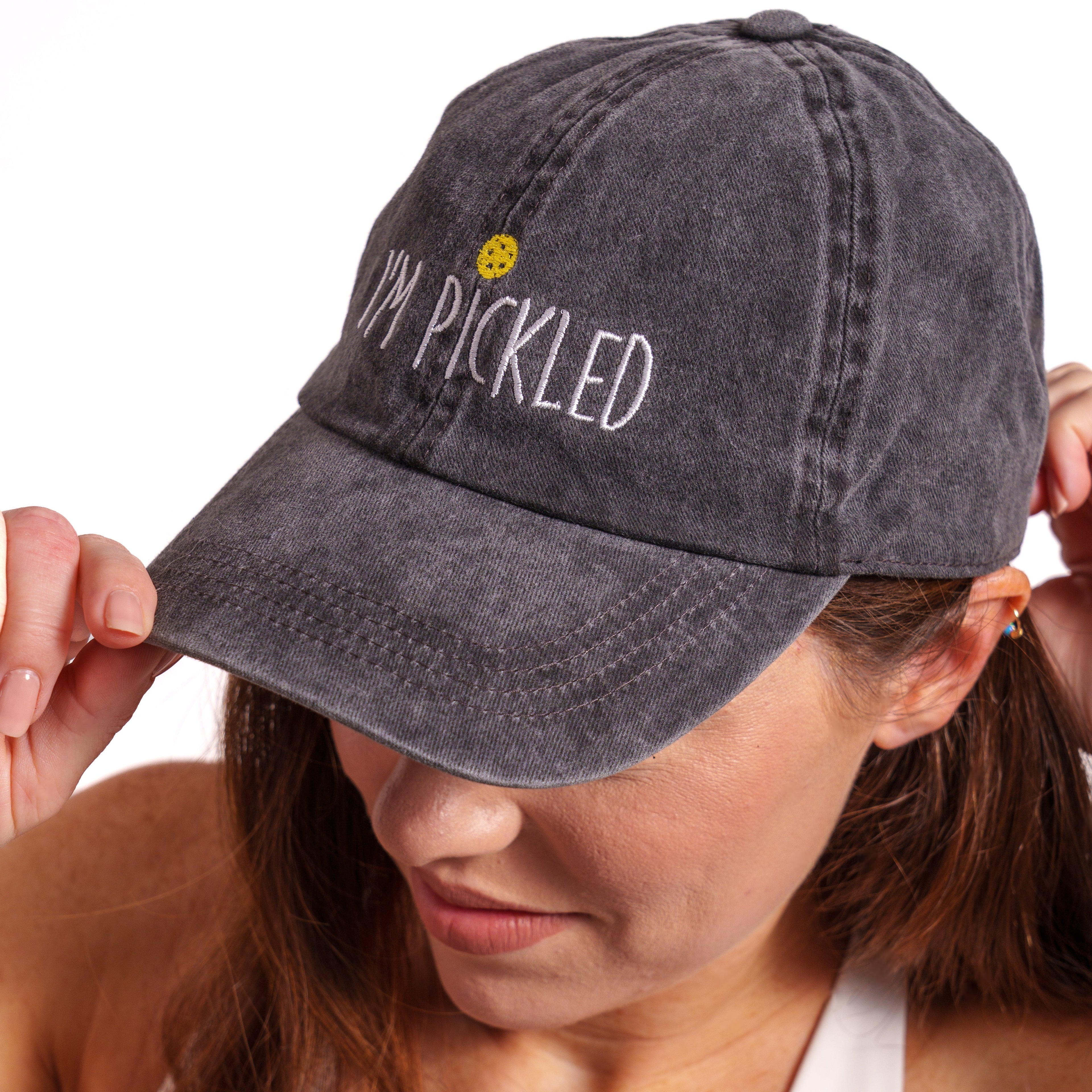 Side view of woman wearing a washed black pickleball themed hat that says &quot;I&