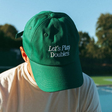 Person wearing Let's Play Doubles baseball hat