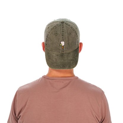 Man wearing a baseball hat backwards with a pickleball paddle and ball embroidered on it